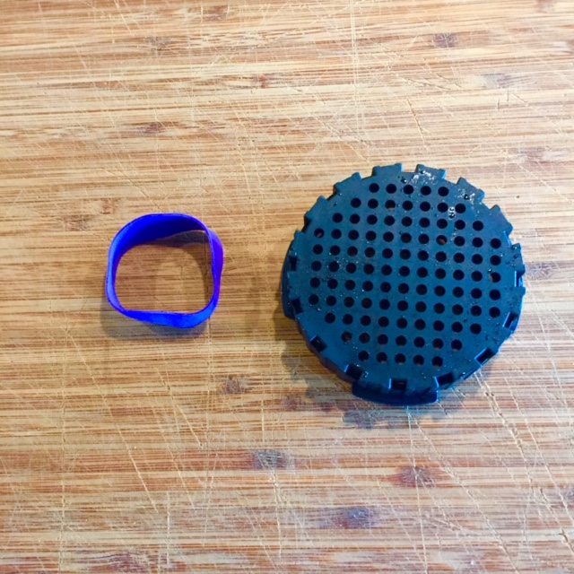 Rubber band next to black plastic AeroPress strainer